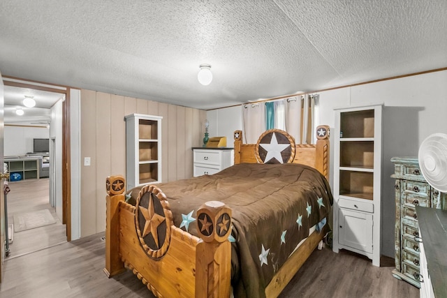 bedroom featuring wood-type flooring and a textured ceiling