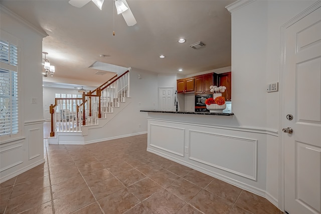 kitchen featuring ceiling fan, light tile patterned floors, ornamental molding, and kitchen peninsula