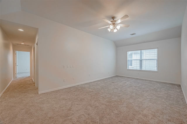 empty room featuring vaulted ceiling, ceiling fan, and light colored carpet