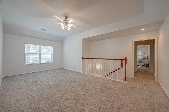 carpeted spare room featuring ceiling fan and lofted ceiling