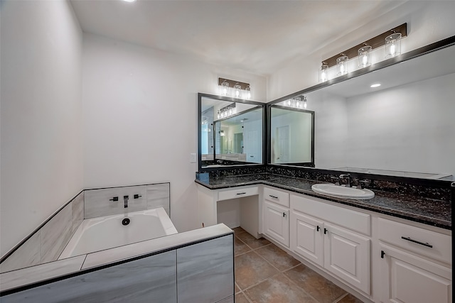 bathroom with tile patterned floors, a washtub, and vanity