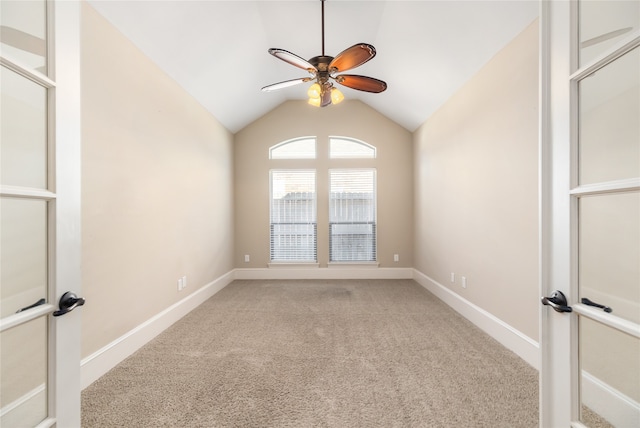 spare room with vaulted ceiling, ceiling fan, and light colored carpet