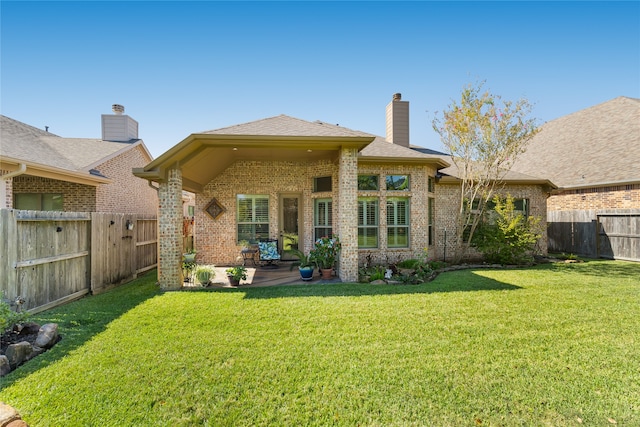 rear view of house with a lawn and a patio area