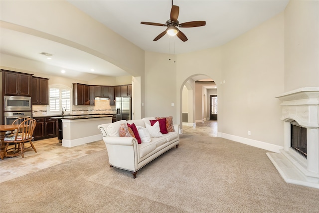 carpeted living room featuring sink and ceiling fan