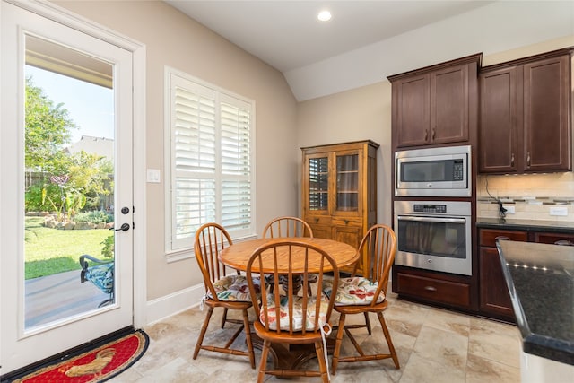 dining space featuring vaulted ceiling and a healthy amount of sunlight