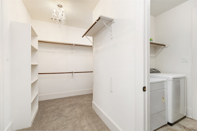 walk in closet featuring washer and clothes dryer and light colored carpet