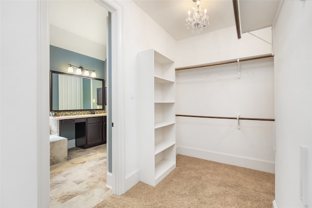 spacious closet featuring sink, light colored carpet, and a notable chandelier