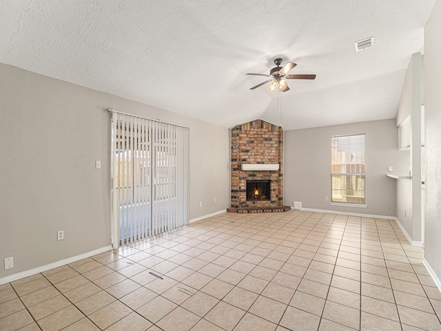 unfurnished living room featuring ceiling fan, light tile patterned floors, a brick fireplace, a textured ceiling, and vaulted ceiling