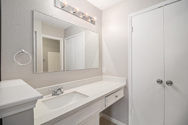 bathroom featuring a textured ceiling and vanity