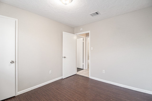 interior space with a textured ceiling and wood-type flooring