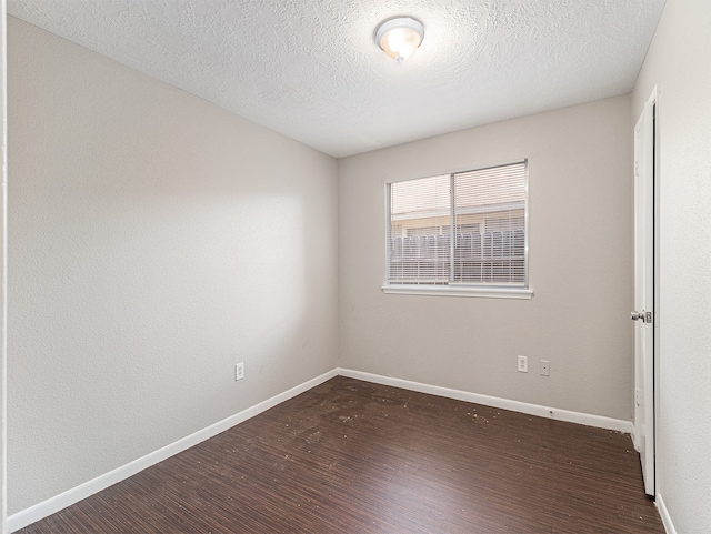 unfurnished room with a textured ceiling and dark hardwood / wood-style floors