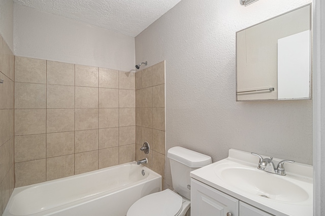 full bathroom with a textured ceiling, tiled shower / bath, vanity, and toilet