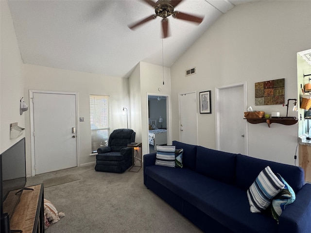 carpeted living room with ceiling fan and high vaulted ceiling