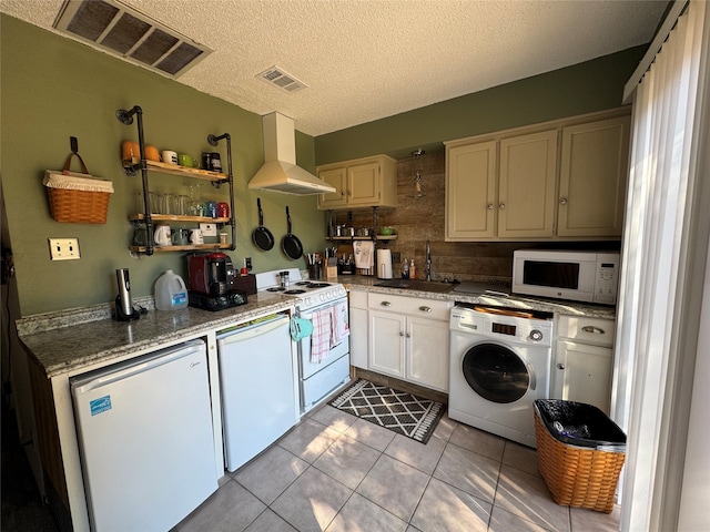 kitchen with white appliances, a textured ceiling, washer / dryer, sink, and extractor fan