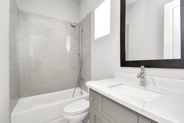 full bathroom with tiled shower / bath, vanity, and toilet