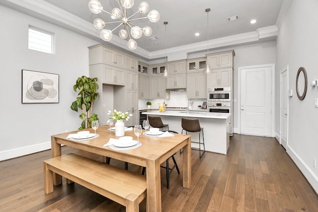 dining area with dark wood-type flooring, ornamental molding, sink, and a notable chandelier