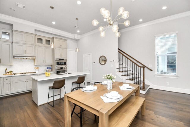 dining space with ornamental molding and dark hardwood / wood-style floors