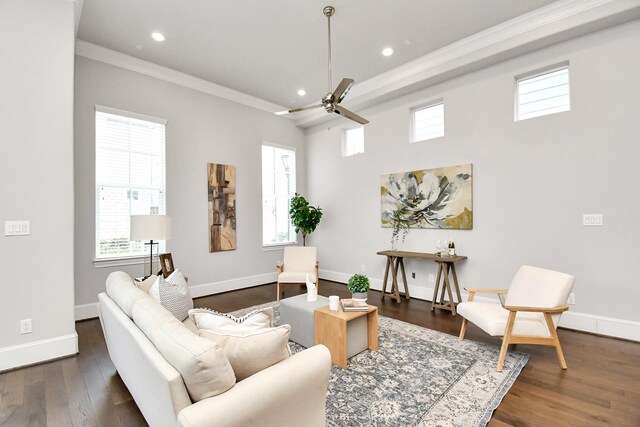 living room with dark wood-type flooring, plenty of natural light, ornamental molding, and ceiling fan