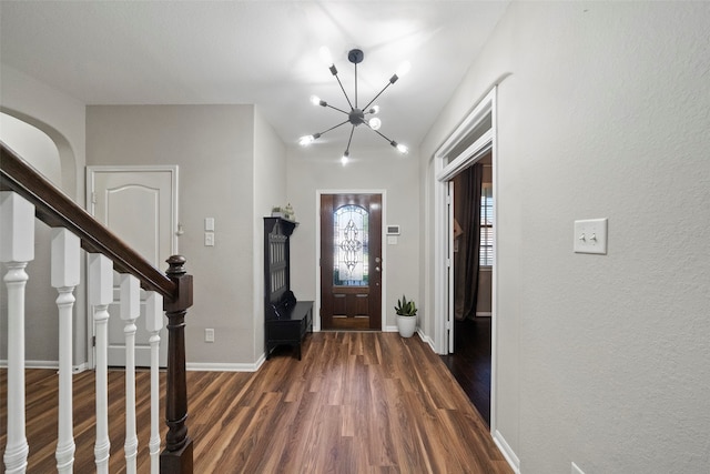 foyer entrance featuring dark hardwood / wood-style floors and a notable chandelier