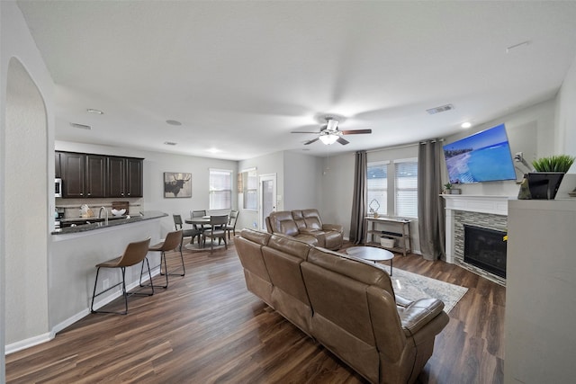 living room with ceiling fan, sink, and dark hardwood / wood-style flooring