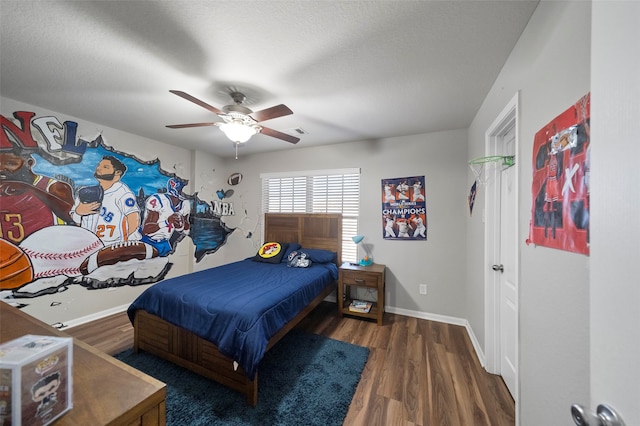 bedroom with a textured ceiling, ceiling fan, and dark hardwood / wood-style flooring