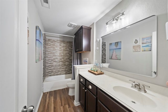 full bathroom with tiled shower / bath, vanity, toilet, and hardwood / wood-style flooring