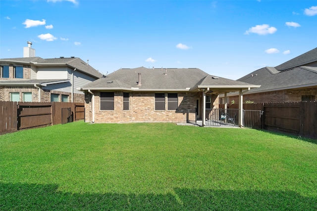 rear view of house featuring a patio area and a yard