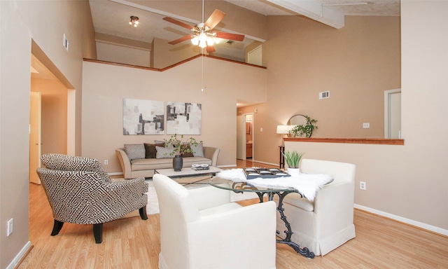 living room with ceiling fan, light wood-type flooring, and high vaulted ceiling