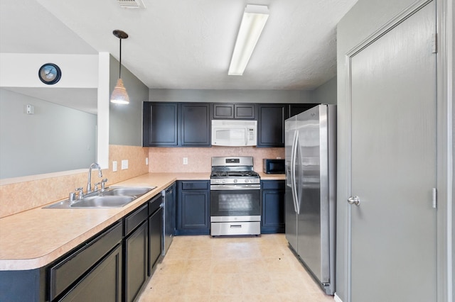 kitchen with tasteful backsplash, kitchen peninsula, stainless steel appliances, decorative light fixtures, and sink