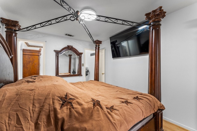 bedroom with baseboards, light wood-style floors, visible vents, and decorative columns