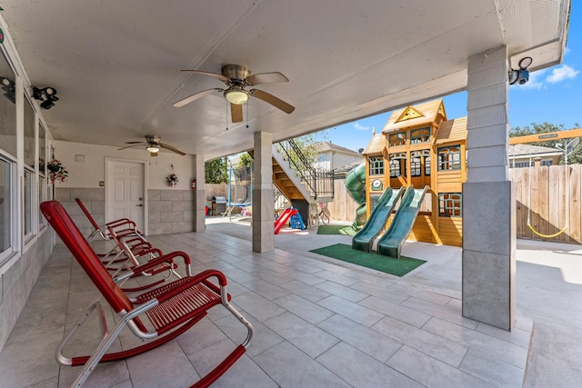 view of patio / terrace with a ceiling fan, a fenced backyard, and a playground