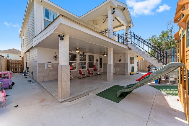 exterior space featuring stairway, fence, and a ceiling fan