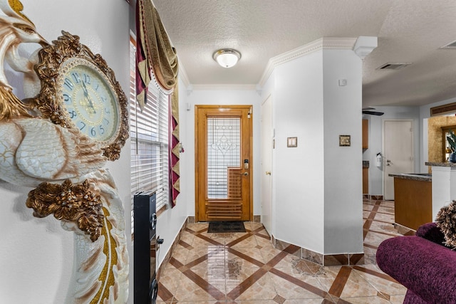 hall featuring baseboards, crown molding, a textured ceiling, and visible vents