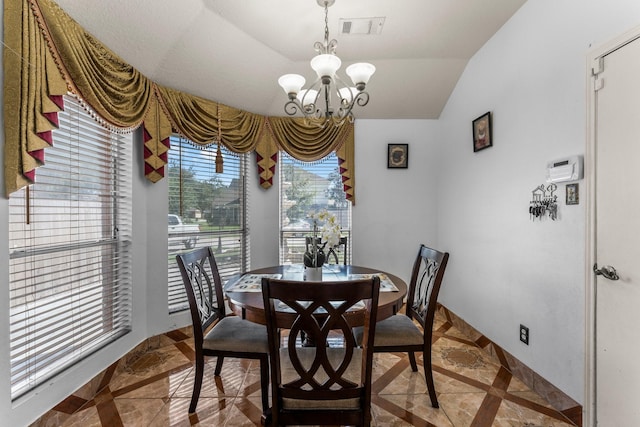 dining area featuring lofted ceiling, baseboards, visible vents, and a notable chandelier