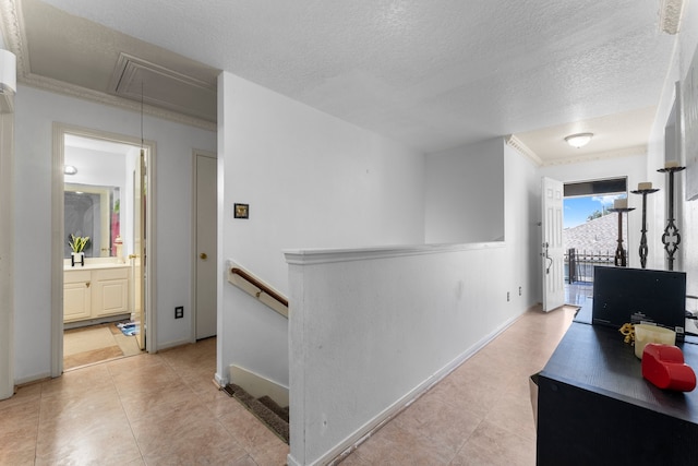 corridor featuring light tile patterned floors, a textured ceiling, and ornamental molding