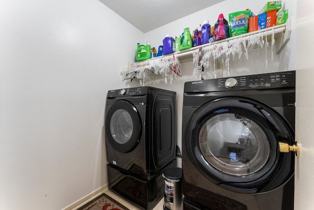 laundry room with a textured ceiling and independent washer and dryer