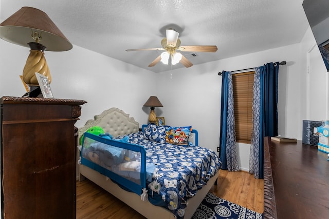 bedroom featuring ceiling fan, a textured ceiling, and hardwood / wood-style floors