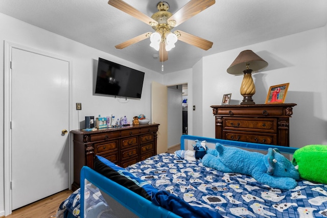 bedroom with a ceiling fan and wood finished floors
