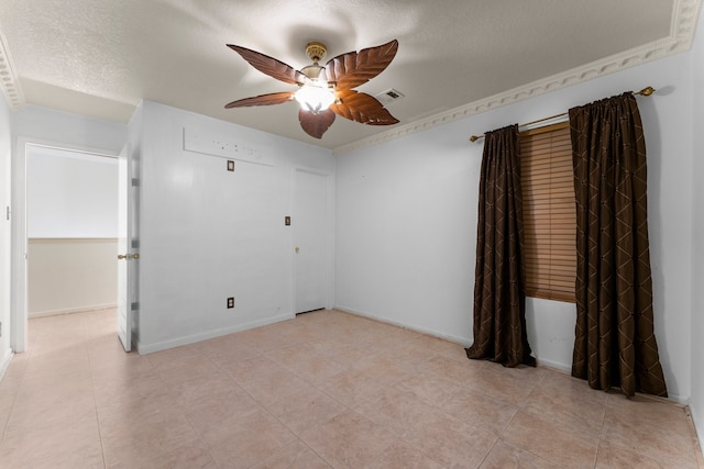 empty room featuring ceiling fan and a textured ceiling