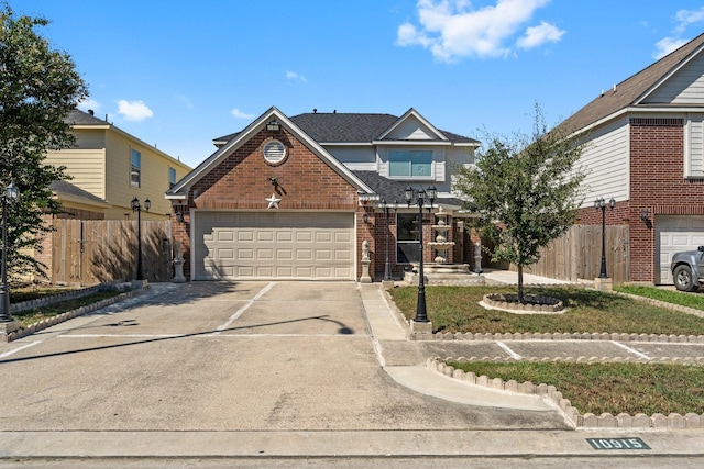 traditional-style home with fence, brick siding, a garage, and concrete driveway