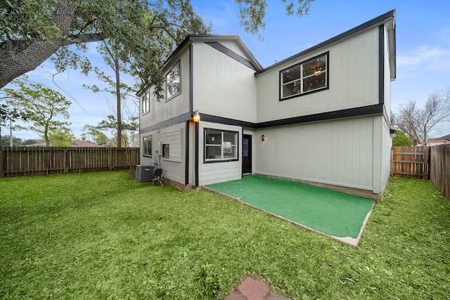 rear view of property with a lawn and central AC