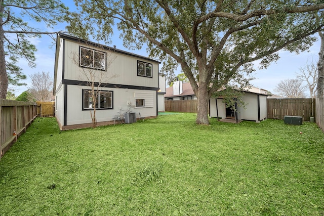 back of house featuring a lawn, a storage unit, and central air condition unit