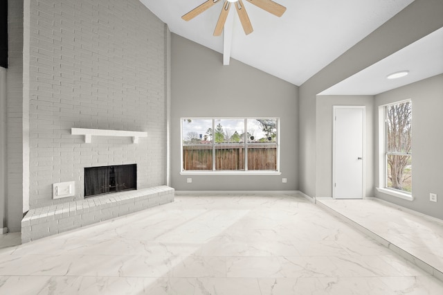 unfurnished living room featuring plenty of natural light, vaulted ceiling, ceiling fan, and a brick fireplace