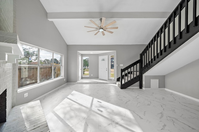 entryway featuring a fireplace, ceiling fan, and high vaulted ceiling