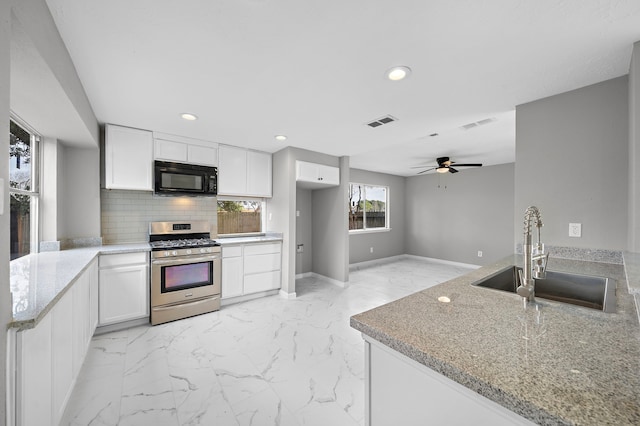 kitchen featuring white cabinetry, kitchen peninsula, stainless steel gas range oven, and sink