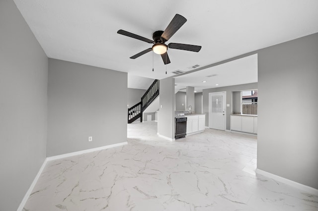 unfurnished living room featuring ceiling fan and sink