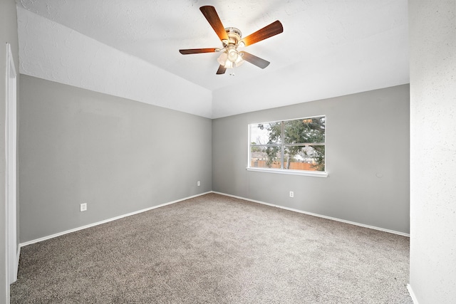 carpeted spare room with ceiling fan, a textured ceiling, and lofted ceiling