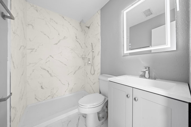 bathroom featuring toilet, vanity, and tiled shower