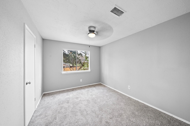 empty room featuring carpet floors, a textured ceiling, and ceiling fan