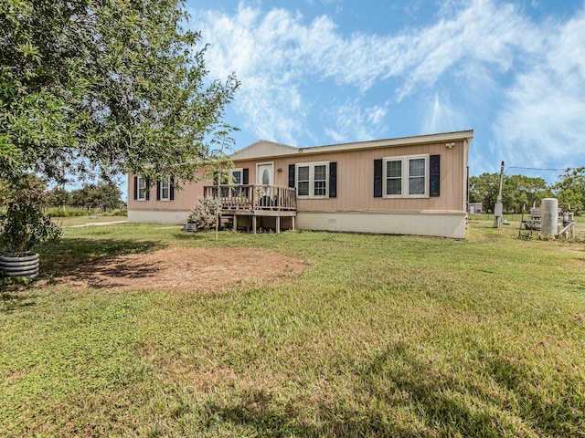 rear view of property featuring a deck and a yard